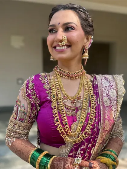 A radiant bride, with glowing makeup and stunning layered necklaces.