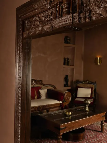 A view into a private consultation area at the House of Masaba, framed by an ornate, antique wooden doorway. This layering of old and new, public and private, is central to the store's narrative of modern Indian luxury.