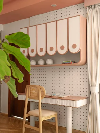 A dedicated study area is essential. This custom desk is paired with playful, curved overhead storage and a versatile pegboard wall, providing a perfect spot for creativity and focus that can be personalized over time.
