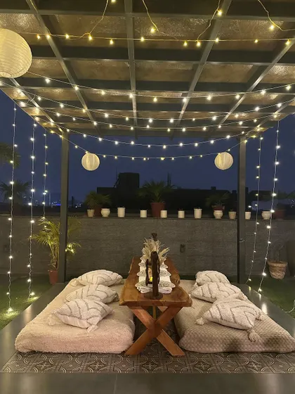 Here is a look at one of my signature boho-chic picnic setups. With low seating on plush cushions, pampas grass accents, and a canopy of fairy lights and paper lanterns, it’s the perfect vibe for a relaxed and soulful evening.