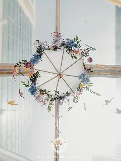 Details from a pastel-themed Mehendi, featuring an umbrella adorned with flowers and hanging origami birds. These delicate touches added a layer of playful elegance to the decor.