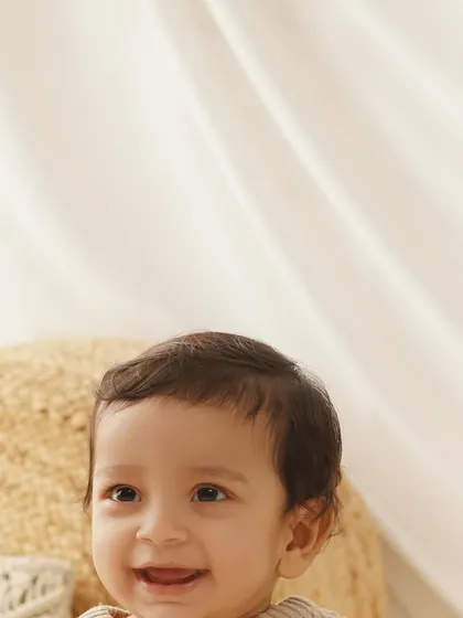 A bright and happy close-up of a baby boy's smiling face, capturing the joy of his first birthday milestone.