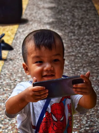 A happy toddler sharing a moment with his grandmother over a phone. This candid photo captures a slice of modern life and the simple, joyful connections between generations.