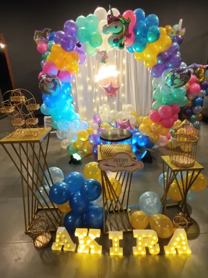 A magical unicorn-themed birthday party is always a favorite. This vibrant setup includes a multi-colored balloon arch, whimsical unicorn and star foil balloons, fairy lights, and marquee letters spelling out the birthday girl's name.