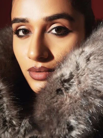A glamorous beauty close-up. The flawless makeup and the texture of the faux fur create a luxurious and high-fashion headshot.