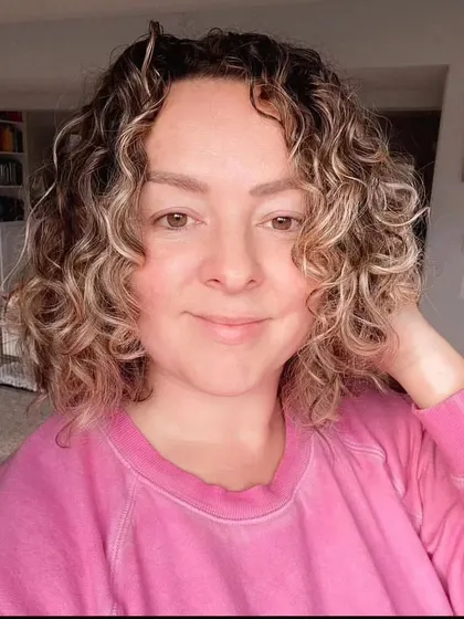 The reference photo for the second portrait of Debi, showing her curly hair and gentle smile.