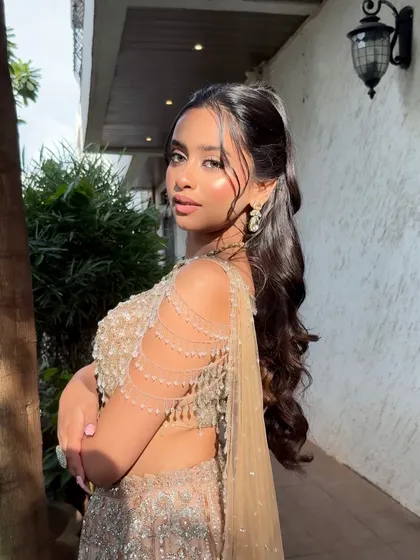 A side profile showcasing the beautiful draping of the outfit and the soft, glowing makeup that looks stunning in natural light.