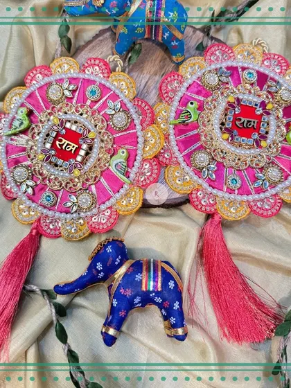 A pink and green version of our "Ram Ram" signs, featuring intricate embroidery, pearl details, and cute parrot motifs.