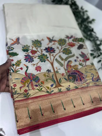 The same exquisite Dola Paithani design on a classic off-white base, allowing the colorful woven motifs to truly stand out.