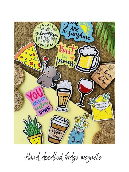 A collection of our little handmade creations, all priced under ₹500. This image shows our hand-doodled fridge magnets with various fun designs and quotes, perfect for adding a bit of joy to your kitchen.
