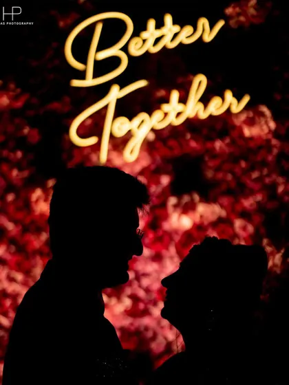 A romantic silhouette of the couple against a "Better Together" sign, perfect for an engagement or reception.