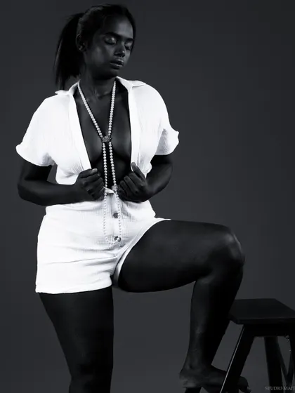 A different pose from the same conceptual series, highlighting the model's form and the dramatic play of light and shadow.