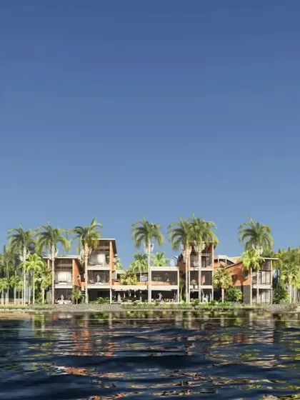 The reflection of the retreat in the calm river water emphasizes the project's harmonious integration with its site.