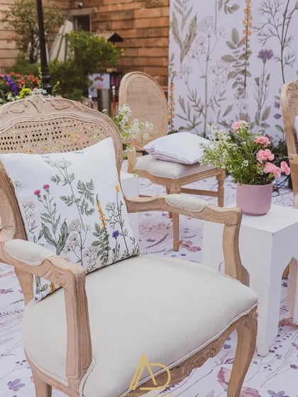 A close-up of a classic wooden chair with a custom-printed cushion, showing how I carry the event's theme through every single detail.