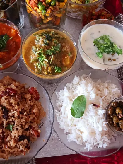 The main course section of the bhog, featuring jaggery rice, clove rice, palak dal, and other traditional preparations.