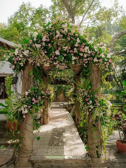 The bridge leading to the pavilion is decorated with a beautiful arch of flowers and greenery.