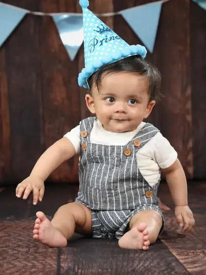 The birthday prince! A cute hat and a simple backdrop are perfect for capturing some classic portraits before the cake smash begins.