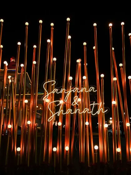 A personalized light installation with the couple's names, creating a unique and modern photo backdrop for their reception at the Lalitha Mahal Palace.