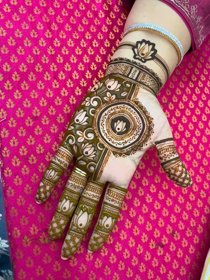 A beautiful lotus mandala design, perfect for any auspicious occasion. The bracelet-like pattern on the wrist adds a modern touch.
