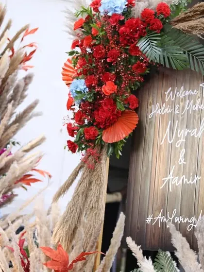 A wider shot of the boho-chic welcome area, showing how the pampas grass and floral arrangements create an immersive entrance.