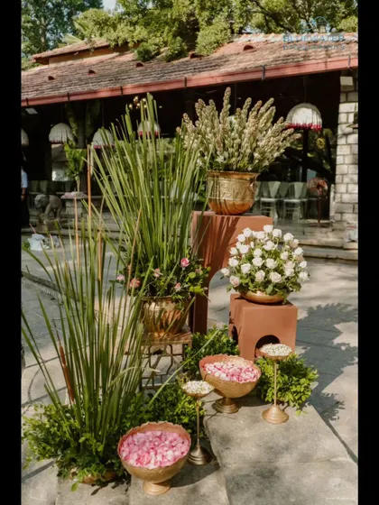 A welcome vignette with brass pots, fresh flowers, and bowls of rose petals.
