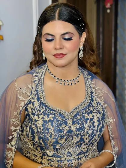 A close-up of a client ready for a reception or sangeet in a royal blue outfit. The bold blue eyeshadow is blended perfectly for a dramatic yet sophisticated look.