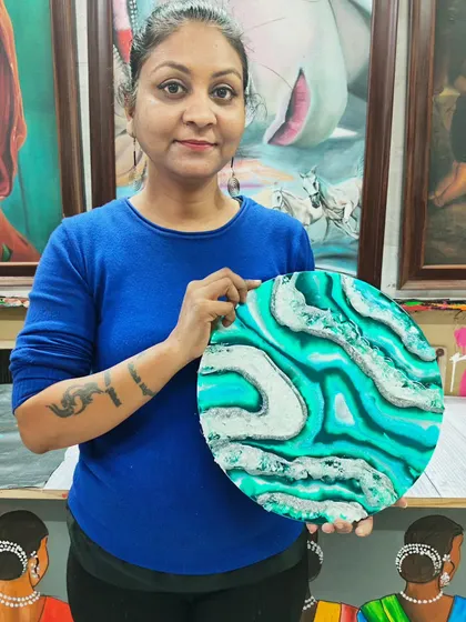 A student proudly displays her finished turquoise and silver resin geode art. Our workshops cover everything you need to know to create these trendy decor items.