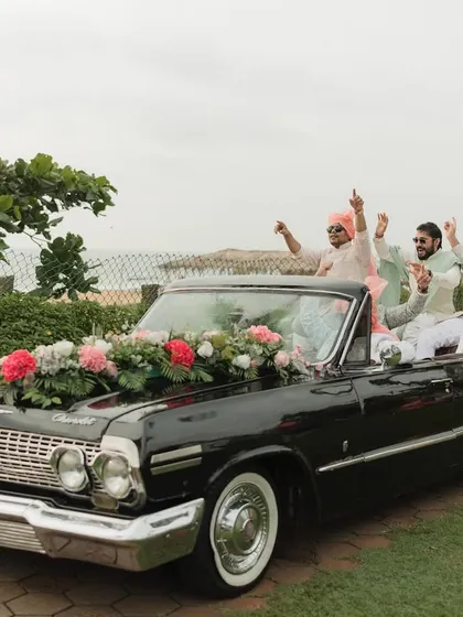 The groom and his squad make a grand entrance in a vintage Chevrolet convertible, driving along the Goan coast. It's all about making a statement.