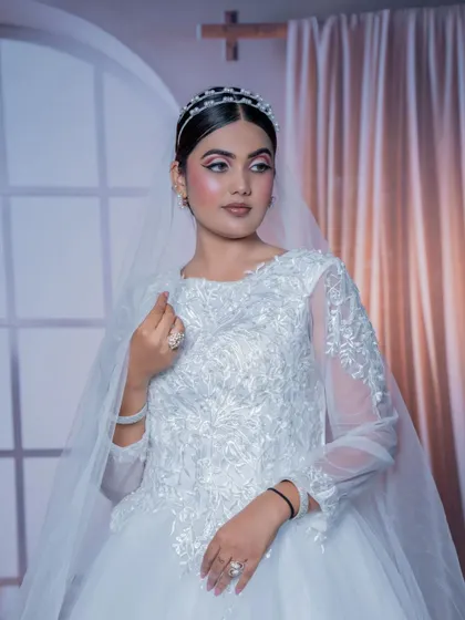 A three-quarter view of the white bridal gown, showing the full skirt and the delicate veil. A timeless rental choice for your wedding day.
