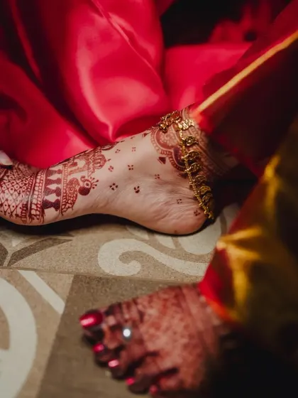 An elegant shot of the bride's foot, showing the beautiful detail of the henna stain and her anklet.