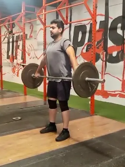 This athlete is in the starting position for a hang snatch. The hang position increases time under tension and builds back strength, which are crucial for improving lifting efficiency.