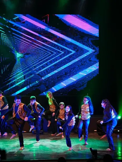 The kids' hip hop crew in the middle of their high-energy routine, with dynamic lighting and background visuals.