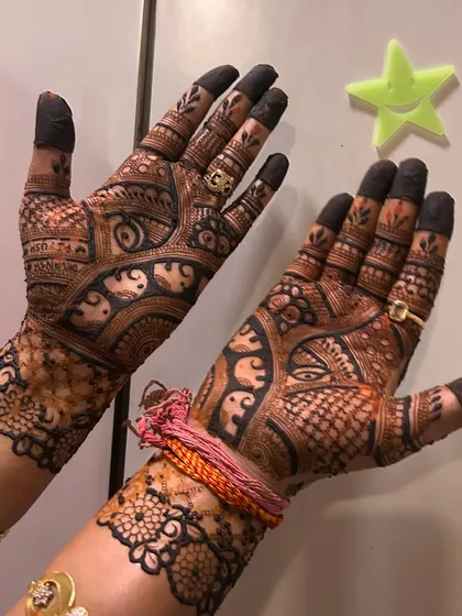 A full coverage design perfect for a bride. The palms are filled with intricate details, including peacocks and elephants, with the fingertips dipped in henna for a traditional finish.