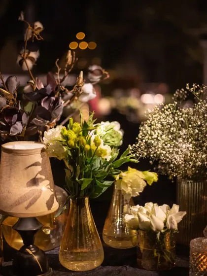 A delicate arrangement of baby's breath and white lisianthus in amber glass vases. The warm tones of the glass and the soft lighting create an intimate and inviting feel.