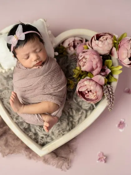 This heart-shaped bowl is one of my favorite props. Here, the baby is nestled inside, surrounded by soft textures and pink peonies for a truly romantic feel.