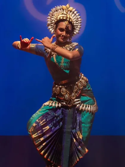 This is the same powerful pose of Meenakshi, captured from a slightly different angle. It highlights the intricate details of the costume and jewelry, which are an integral part of the performance aesthetic.