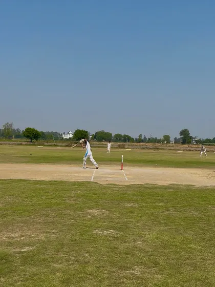 A wide shot of Aditi batting, showing her command at the crease.