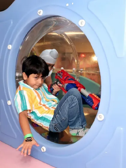 A boy finds a cozy spot to play inside one of the tunnels in our soft play structure.