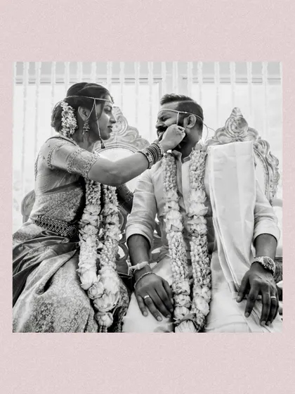 A playful and tender moment between the bride and groom during their wedding ceremony. The intricate details of their attire and our floral garlands are beautifully highlighted.