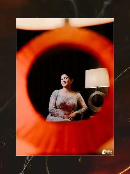 An artistic shot of bride Airika, framed through a circular orange object, creating a unique and creative composition for her portrait.