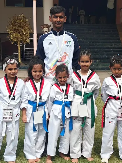 A coach stands with his team of young female competitors, who performed exceptionally well at the Pune championship.