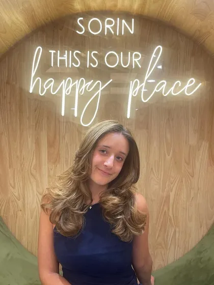 A beautiful smile from a satisfied client after her hair makeover.