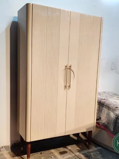 A tall, stately cabinet with fluted doors and distinctive circular brass hardware. We designed this piece to serve as a commanding storage unit, blending art deco influences with modern craftsmanship.