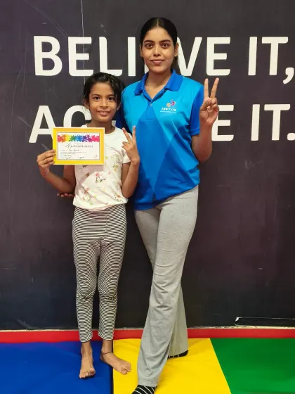 This student and her coach celebrate her new certificate with matching peace signs.