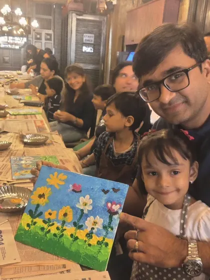 A heartwarming moment between a father and daughter as they complete their floral canvas painting at a birthday party. My sessions are designed for families to bond and share a creative experience.