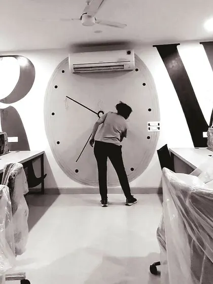 A behind-the-scenes look at the 'GROWTH' office mural, showing me working on the clock detail. The office is still being set up, highlighting that I can work in various site conditions.