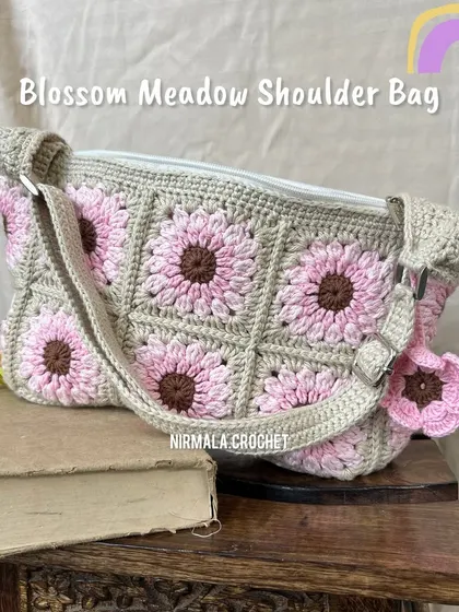Our Blossom Meadow bag styled on a stack of books, showing its vintage-inspired charm. The adjustable strap makes it comfortable to wear.
