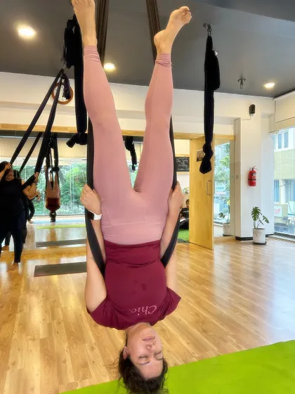 A student enjoying the feeling of being upside down, a common and joyful experience in our aerial classes.