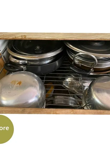 This "before" shot shows a drawer with pots and pans stacked haphazardly, making it difficult to get to the items at the bottom.