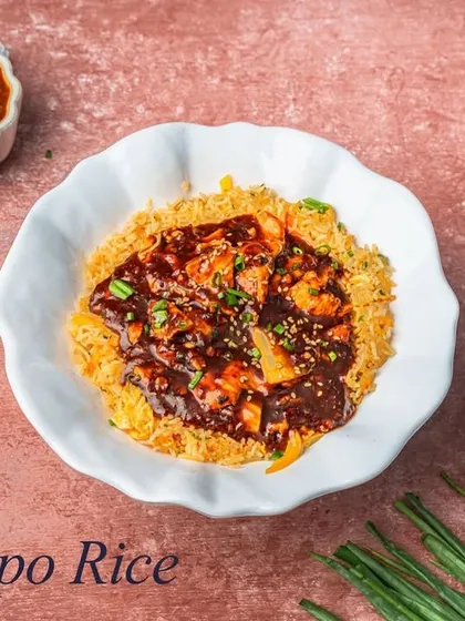 Dongpo Rice is a savory dish featuring a bed of crispy noodles and rice topped with chicken or vegetables in a rich, dark, and flavorful sauce. It's a complete meal in a bowl.